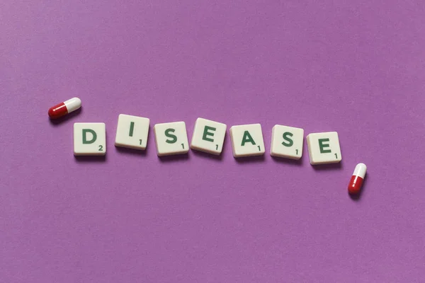 Ασθένεια Λέξη Που Σχηματίζεται Από Scrabble Μπλοκ Και Φαρμακευτική Χάπια — Φωτογραφία Αρχείου