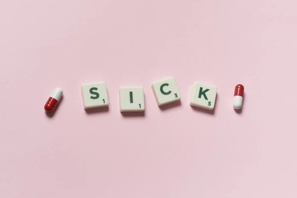 Palavra Doente Formada Por Blocos Scrabble Pílulas Farmacêuticas Sobre Fundo — Fotografia de Stock