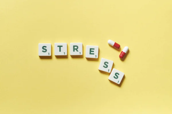 Stress Woord Gevormd Van Scrabble Tegels Farmaceutische Pillen Gele Achtergrond — Stockfoto