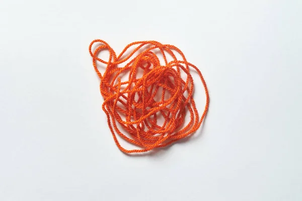 Red tangled thread on white background. Anxiety and mental health awareness.