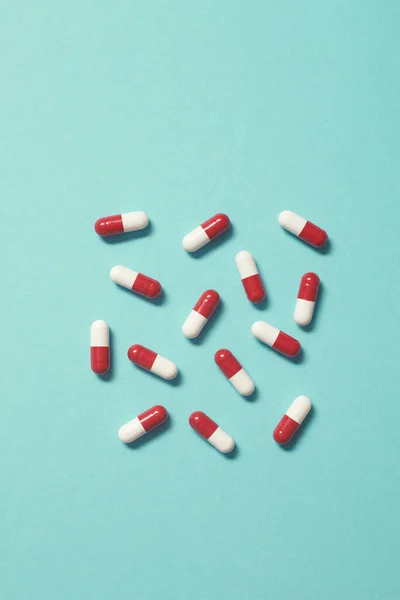 Turkuaz Zemin Üzerine Serpiştirilmiş Kırmızı Beyaz Ilaç Hapları Kopyalama Alanı — Stok fotoğraf