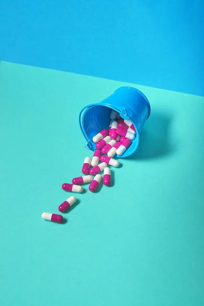 薬の丸薬は緑と青の背景でバケツから落ちる テキストのための場所とフラットレイアウト — ストック写真