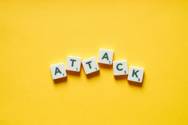 Palabra Ataque Formada Por Azulejos Scrabble Desordenado Sobre Fondo Amarillo —  Fotos de Stock