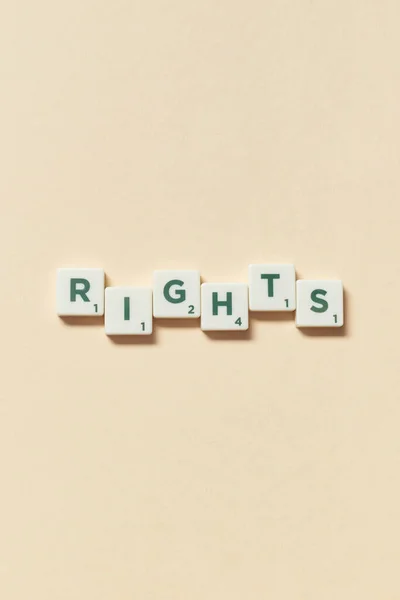 Rights word formed of scrabble tiles on beige background. Social awareness and education concept.
