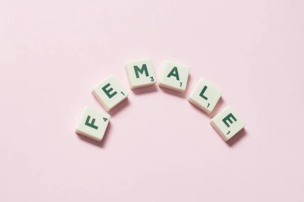 Female Word Formed Scrabble Tiles Pink Background Social Awareness Education — Stock Photo, Image