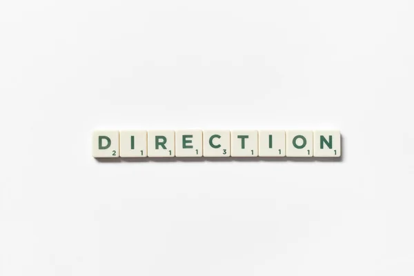 Word Direction Formed Scrabble Tiles White Background Simple Creative Backdrop — Photo