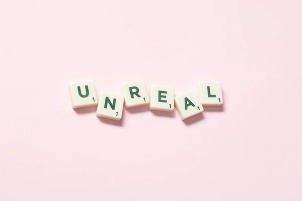Szó Irreális Kialakult Scrabble Csempe Rózsaszín Háttér Csendes Élet Másolási — Stock Fotó