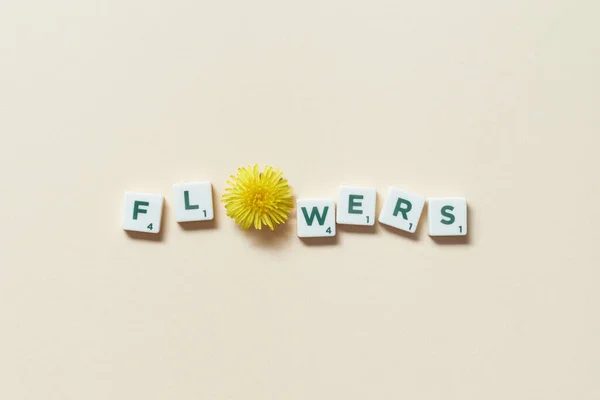 Kwiaty Słowo Utworzone Scrabble Płytek Świeżym Kwiatem Mniszka Lekarskiego Beżowym — Zdjęcie stockowe