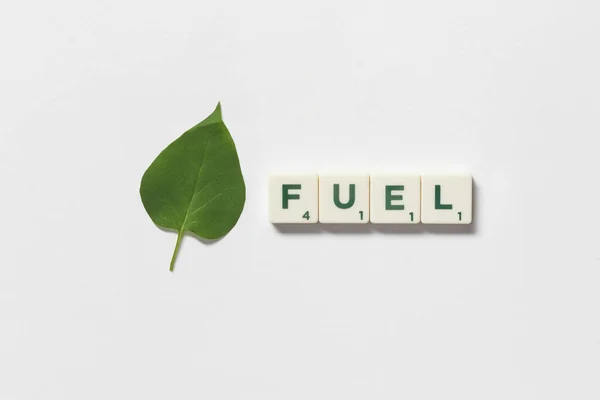 Fuel Word Formed Scrabble Tiles Green Tree Leaf White Background — Stockfoto