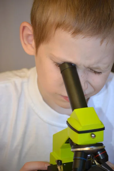 Pojken med ett Mikroskop — Stockfoto