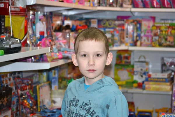 De jongen in de winkel met speelgoed — Stockfoto