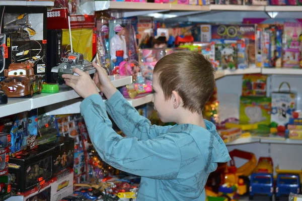 Der Junge im Geschäft mit Spielzeug — Stockfoto