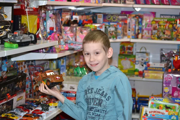 De jongen in de winkel met speelgoed — Stockfoto