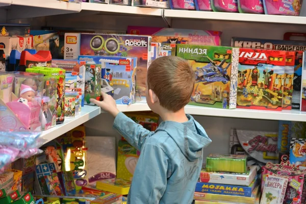 Der Junge im Geschäft mit Spielzeug — Stockfoto