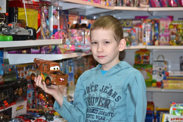 De jongen in de winkel met speelgoed — Stockfoto