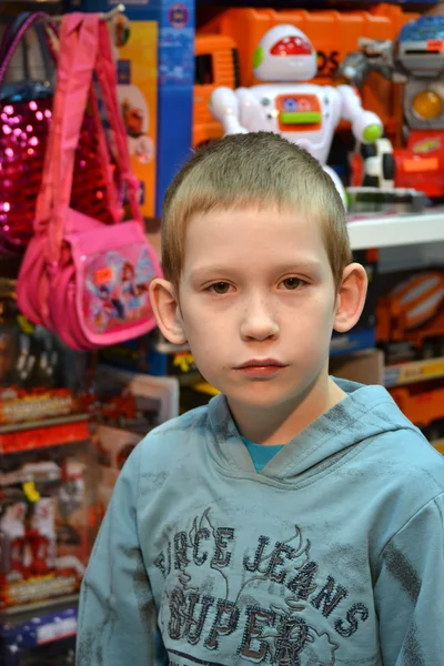 De jongen in de winkel met speelgoed — Stockfoto