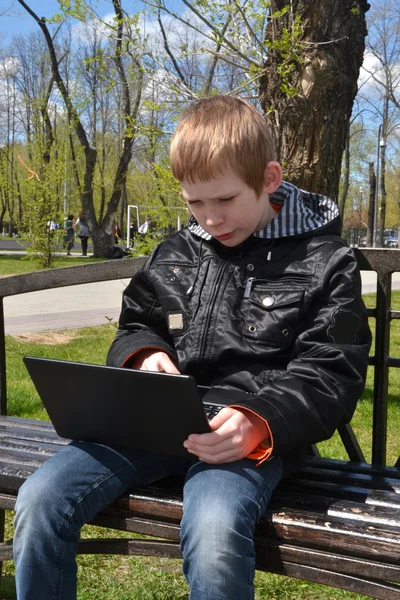 O adolescente com o computador portátil — Fotografia de Stock