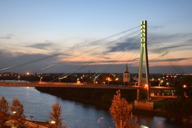 The bridge for pedestrians through the Tura River, Tyumen, in ni clipart