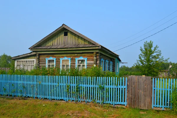 Dřevěný dům v obci v létě. — Stock fotografie