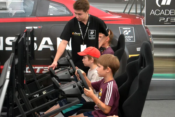 Dospívající chlapci řídit simulátory závodních hru na nismo g-driv — Stock fotografie
