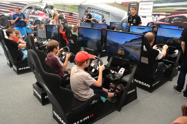 Teenagerů řídit simulátory závodních hru na g-drive s nismo — Stock fotografie