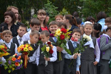 Öğrenciler ellerinde çiçeklerle 1 Eylül standı.