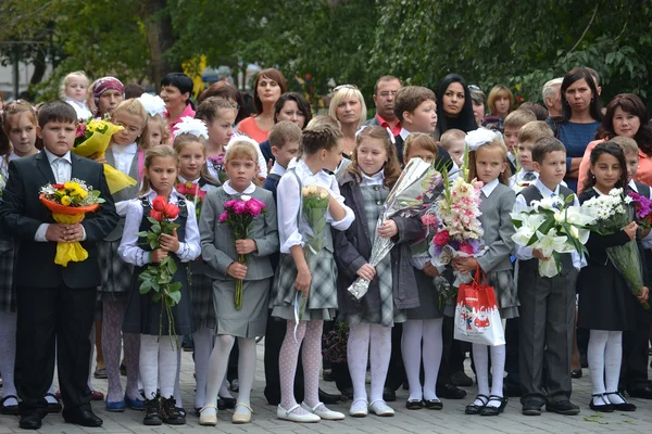 Schüler stehen mit Blumen in der Hand am 1. September. — Stockfoto