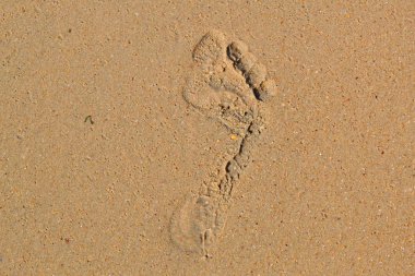 kişinin kum üzerinde çıplak ayak izi