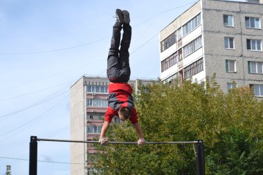 evin bahçesinde yatay bir çubuk üzerinde spor için adam giriyor