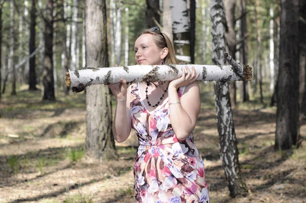 La jeune femme avec une bûche dans le bois . — Photo