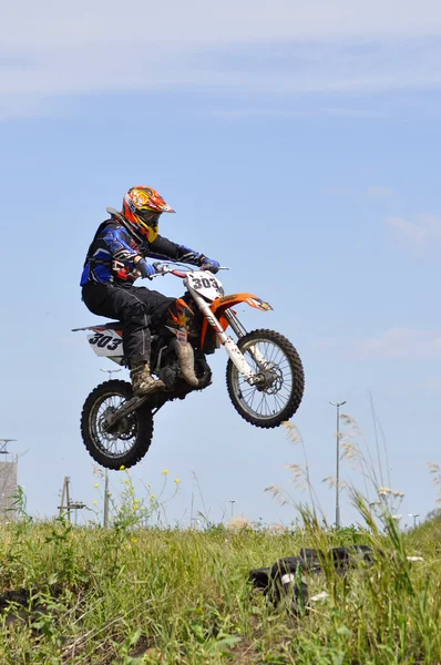 O motociclista na moto realiza um salto contra o th — Fotografia de Stock