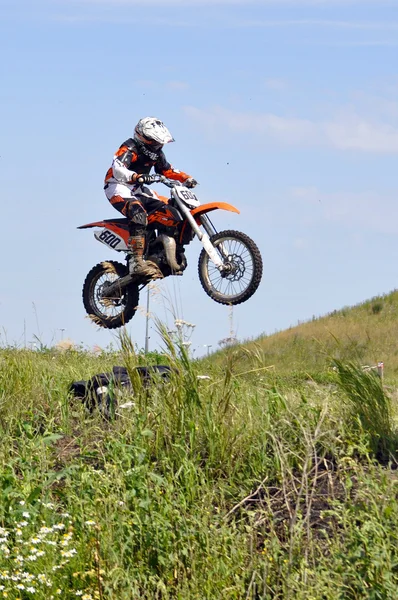 O motociclista na moto realiza um salto contra o th — Fotografia de Stock