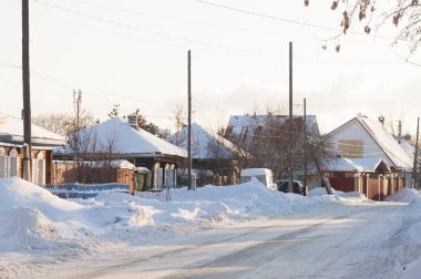 Rusya 'daki köyün karlı caddesinde birkaç yerleşim yeri var.