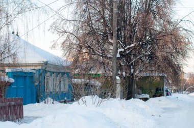 Rusya 'daki köyün karlı caddesinde birkaç yerleşim yeri var.