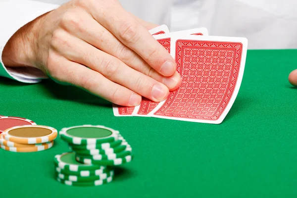 Adam bir kumar masasında kartları ile — Stok fotoğraf