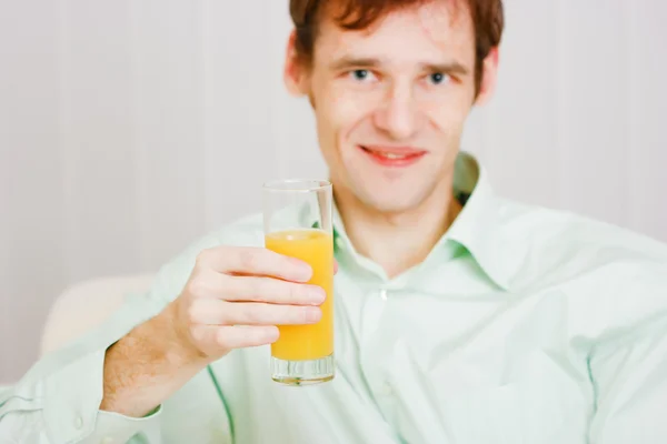 Sonriente hombre con un jugo de vidrio —  Fotos de Stock