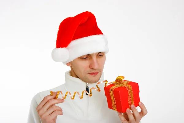 Young man in a Santa hat holding gift — Stock Photo, Image