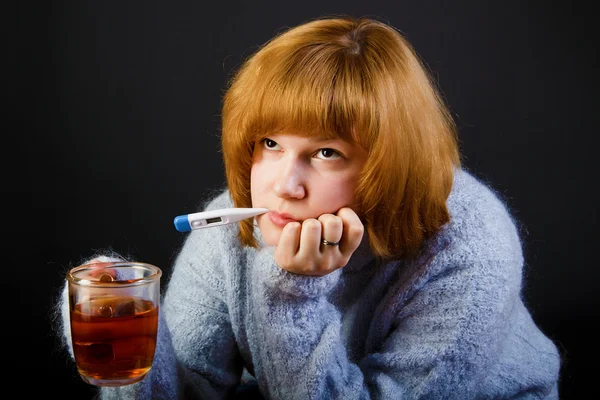 Menina doente com chá e um termômetro — Fotografia de Stock