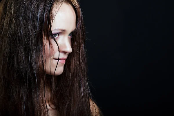 Beautiful girl with long wet hair on a black background — Stock Photo, Image