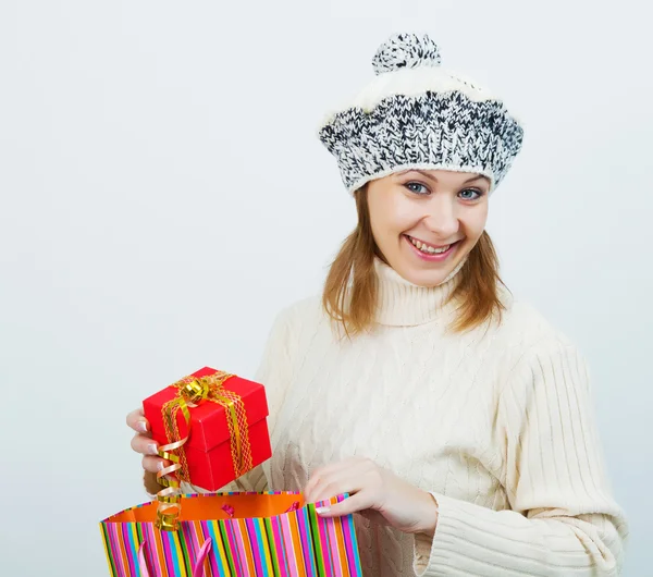 Attractive girl in a sweater holding a gift — Stock Photo, Image