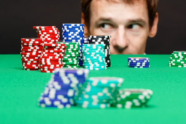 Man looking under the table on playing chips — Stock Photo, Image