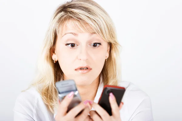 Stående flicka med två mobiltelefoner — Stockfoto