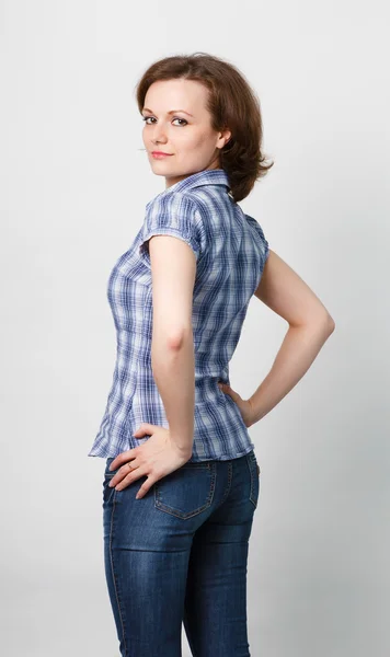 Flicka i en rutig skjorta och jeans — Stockfoto