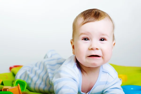 Little baby boy with toys weeps — Stock Photo, Image