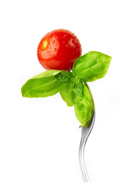 Fork with fresh tomato and basil — Stock Photo, Image