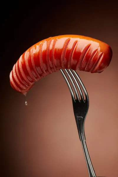 Grilled sausage on a fork — Stock Photo, Image