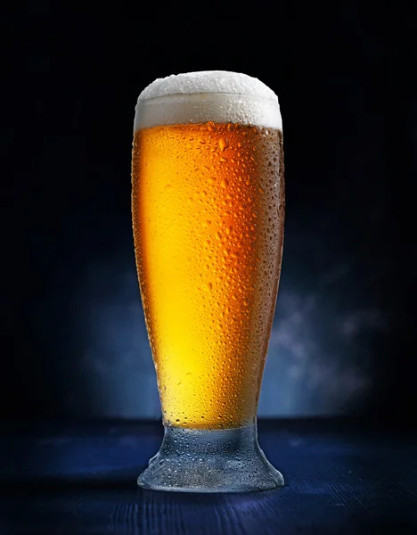 Glass of beer on dark blue background — Stock Photo, Image