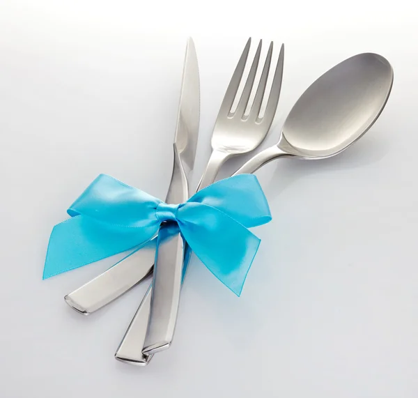 Knife fork and spoon with blue ribbon — Stock Photo, Image