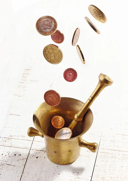 Euro coins falling into mortar and pestle — Stock Photo, Image