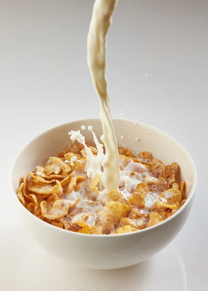 Mleko leje do miski z płatki kukurydziane — Zdjęcie stockowe